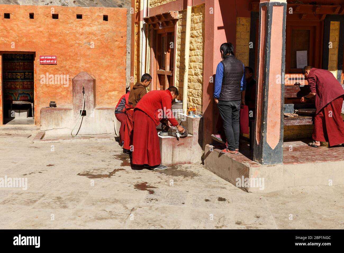 Kagbeni, Mustang District, Nepal - November 19, 2016: Buddhist monks teenagers wash dishes after dinner in the courtyard of the temple. Stock Photo