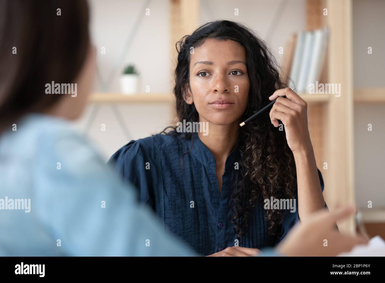 Close up focused african american businesswoman listening new female applicant. Stock Photo