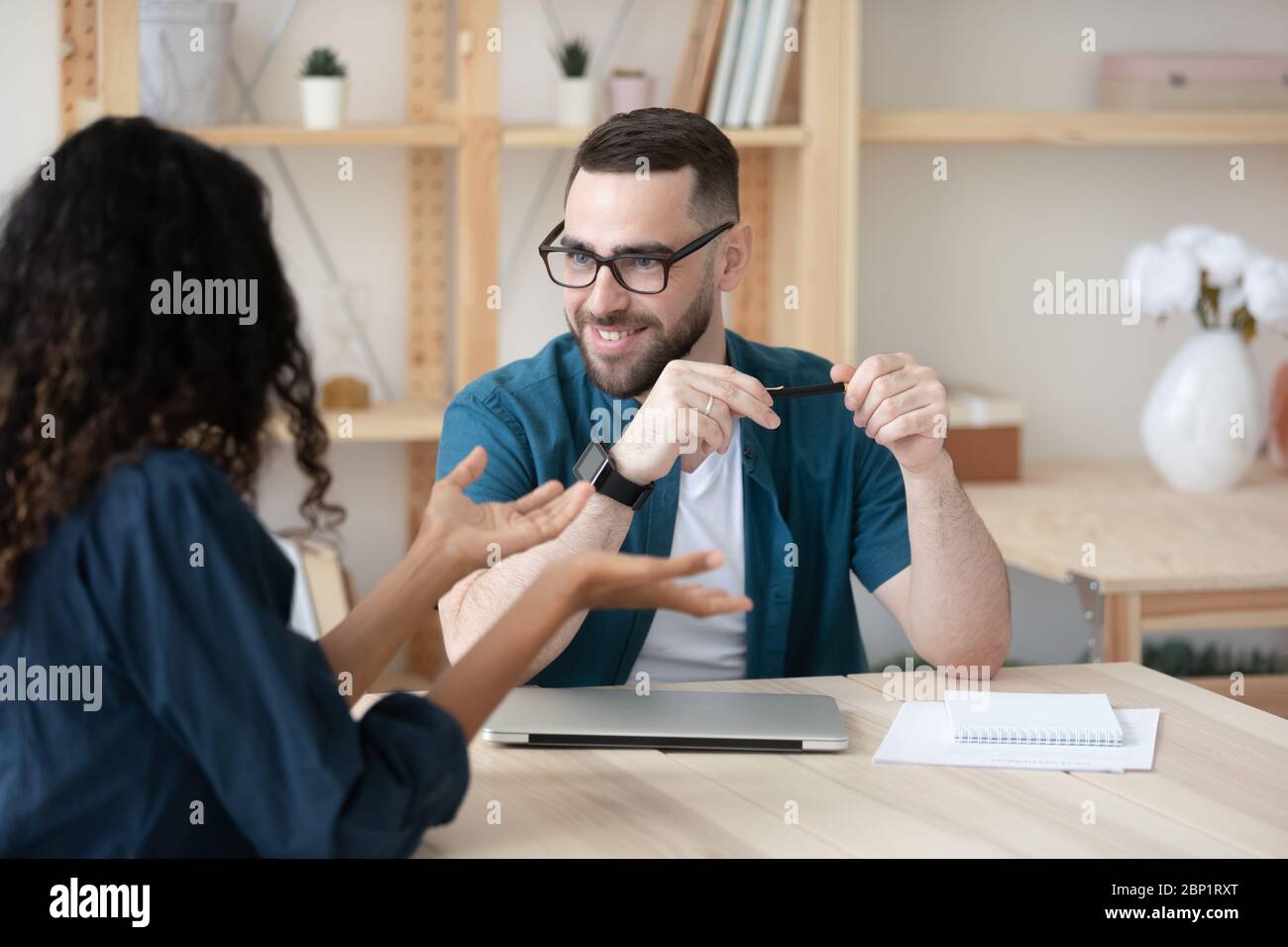 Smiling male hr manager listening new young applicant introduction. Stock Photo