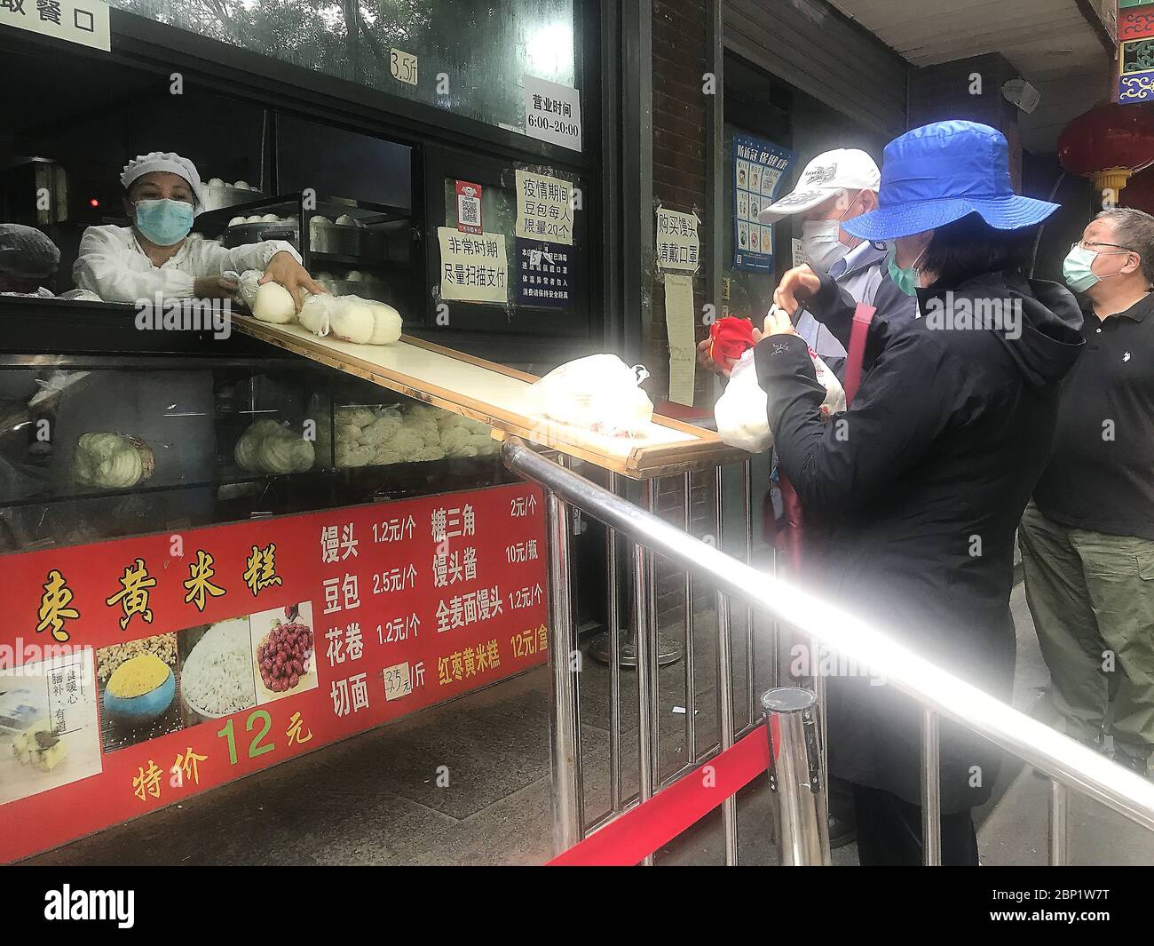Beijing, China. 17th May, 2020. Chinese order dumplings and buns via an impromptu 'bridge' as they practice 'social distancing' and continue wearing protective face masks outside in downtown as the coronavirus pandemic threat continues in Beijing on Sunday, May 17, 2020. Wuhan, a city of 11 million, where the Covid-19 pandemic originated, reported new cases over the weekend, its first new infections in over a month. China is aggressively investigating the new cluster, announcing a plan to test the entire city in 10 days. Photo by Stephen Shaver/UPI Credit: UPI/Alamy Live News Stock Photo