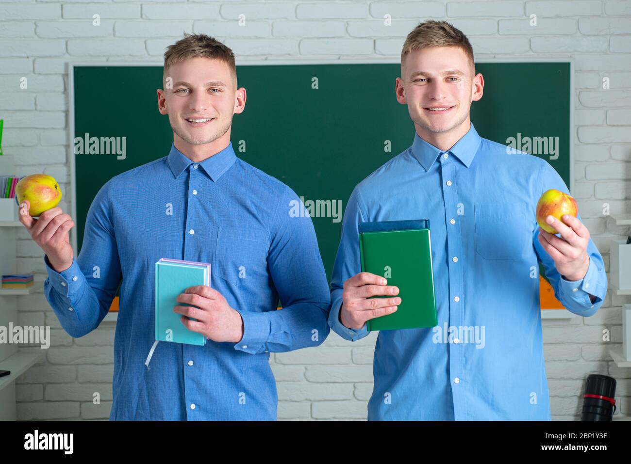 Two student holding books and smiling at camera. Learning and education ...