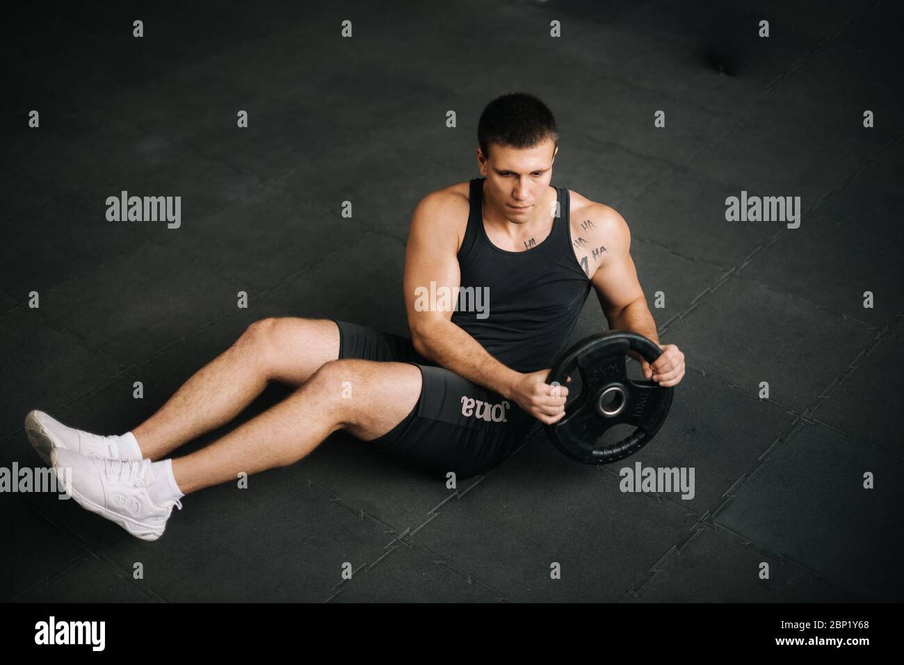 Muscular strong man doing russian twist exercise with weight from barbell  Stock Photo - Alamy