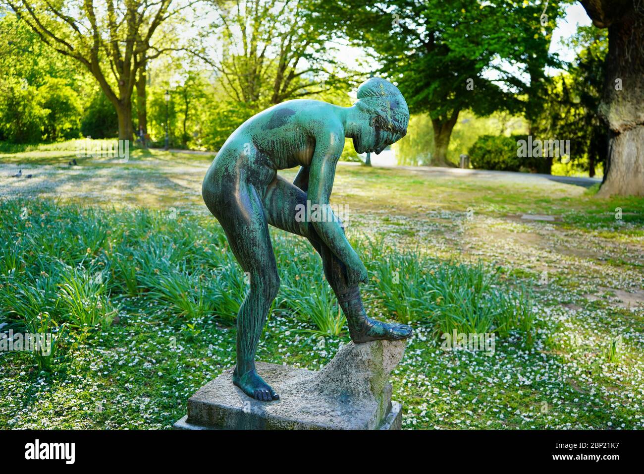 'Sandalenbinderin' (English: girl tying her sandal) is a bronze sculpture by the sculptor August Kraus. It was completed in 1901. Stock Photo