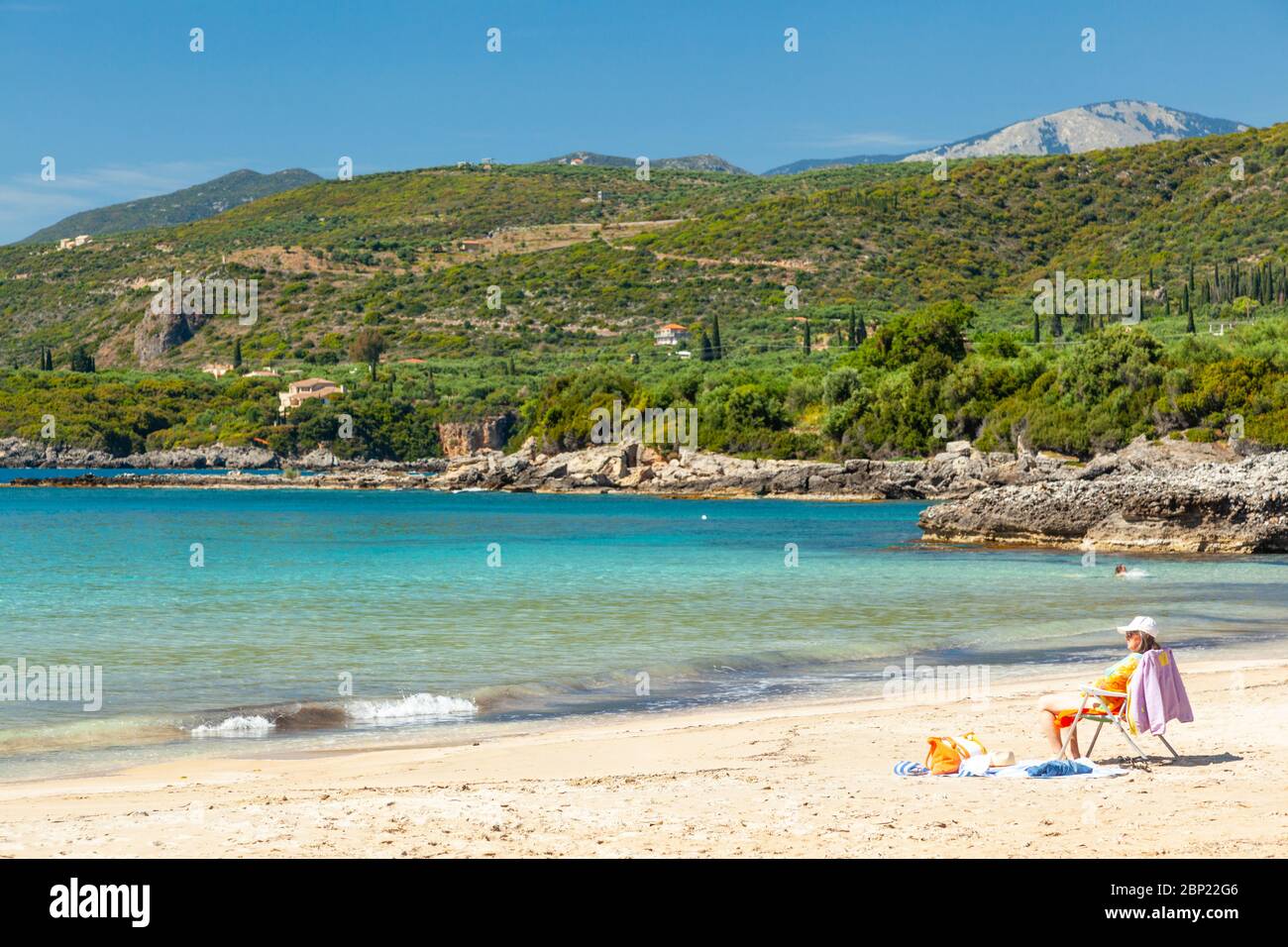 Tourist enjoying the sun in the beach of Kalogria, near Kardamyli town, in Western Mani, Messinia region, Peloponnese, Greece. Stock Photo