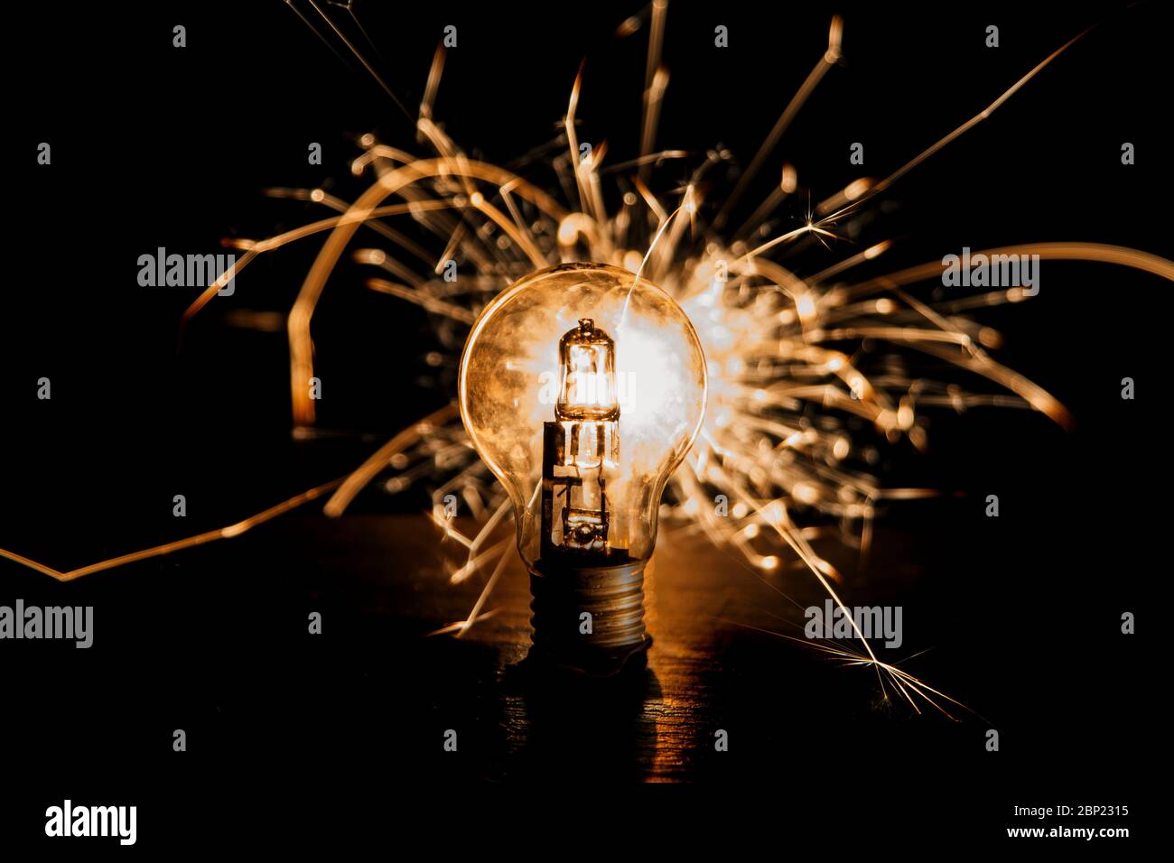 Electricity. Lightbulb lit up with sparklers behind it. Bright idea, bright spark Stock Photo