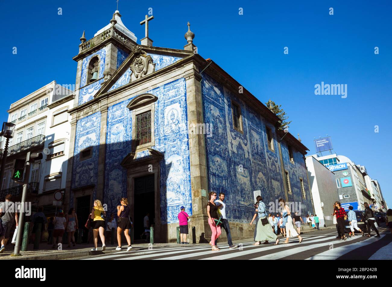 Porto, Portugal : People walk past the blue azulejo adorned walls of the Capela das Almas chapel. Stock Photo