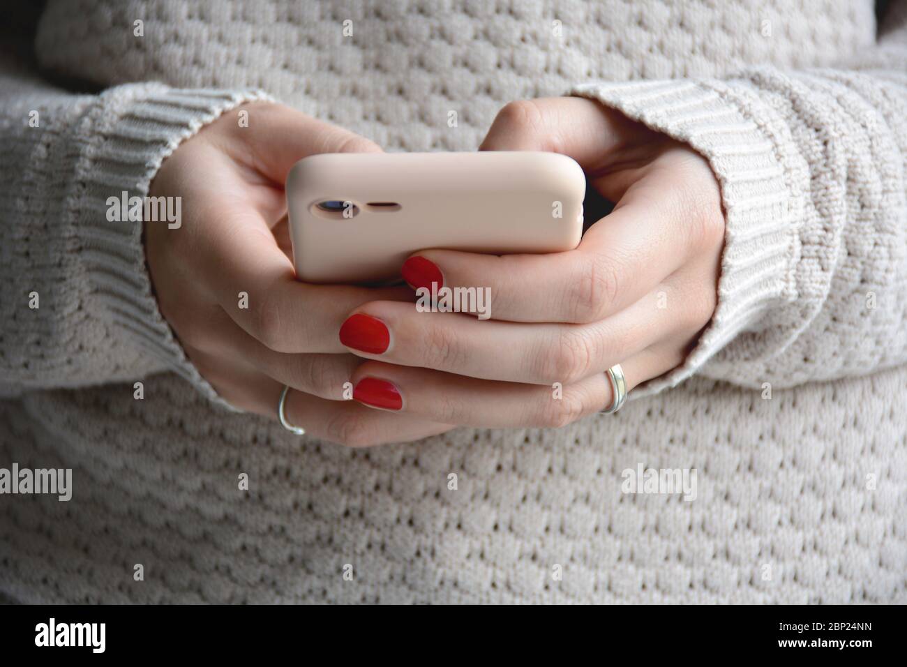 Close up woman with red nails using her mobile phone. Sending a message with smartphone. Front view Stock Photo