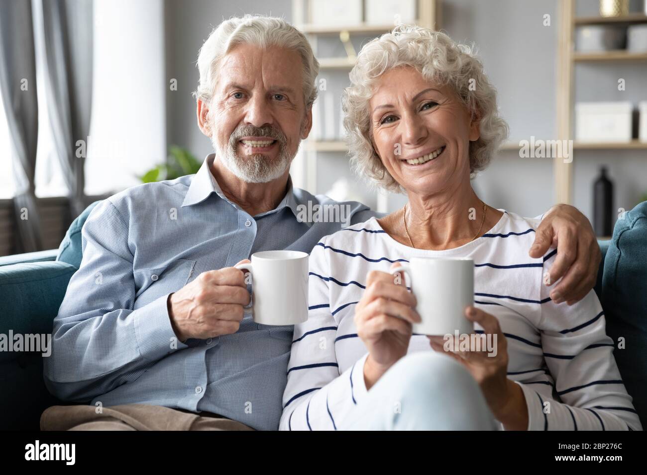 Smiling retired family spouses enjoying lazy weekend morning time. Stock Photo