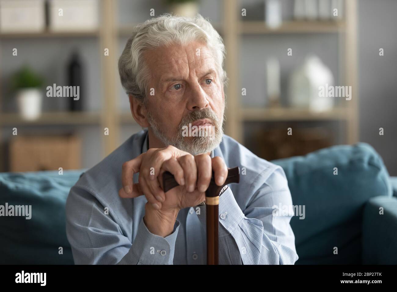 Upset middle aged mature grandfather thinking of disability. Stock Photo