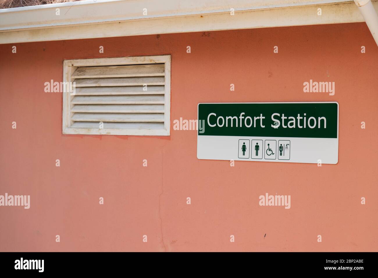 Plastic rectangular sign - comfort station stuck on a painted rendered wall Stock Photo