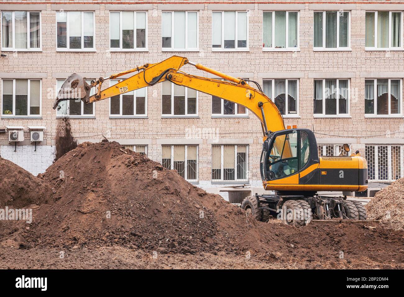 Excavator digs a hole on the construction site territory Stock Photo ...