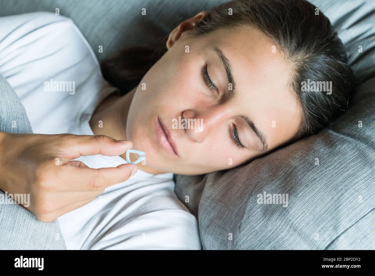 Woman using a nasal clip, anti snoring device. Stock Photo