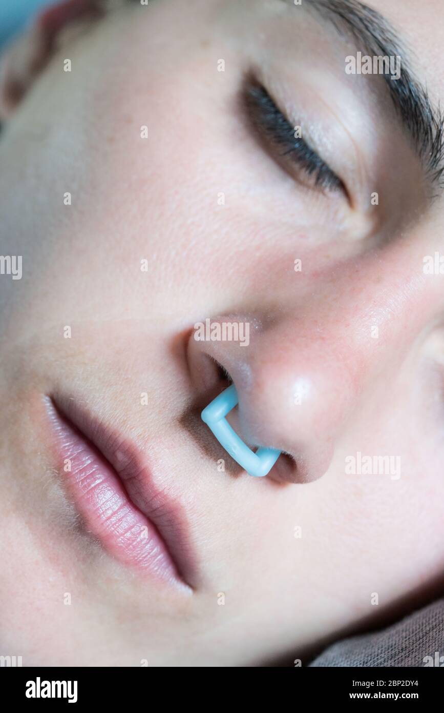 Woman using a nasal clip, anti snoring device. Stock Photo