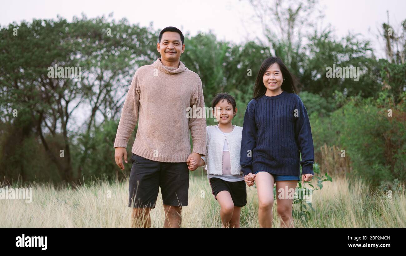 Asian family with father mother and daughter have walking in the park ...