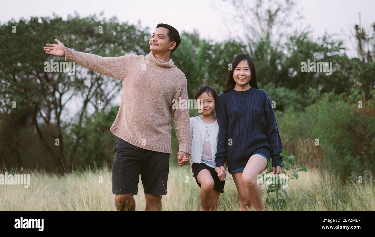 Asian family with father mother and daughter have walking in the park ...