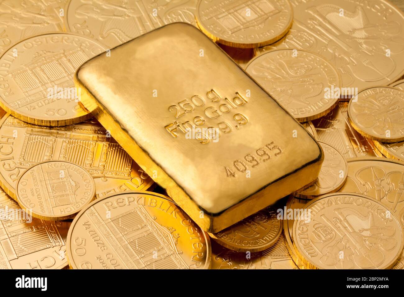 Gold als Wertanlage in Goldbarren und Muenzen, 100 US-Dollar Banknoten im  Hintergrund Stock Photo - Alamy