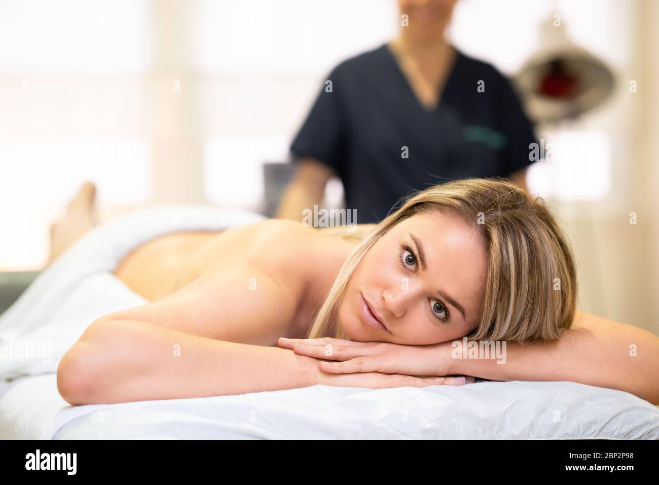 Woman lying on a stretcher at a physical therapy center. Stock Photo
