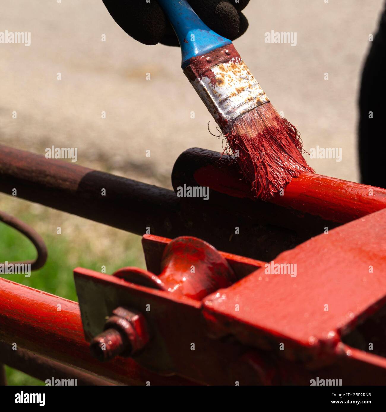Hand with brush that painting metal railing construction, close up