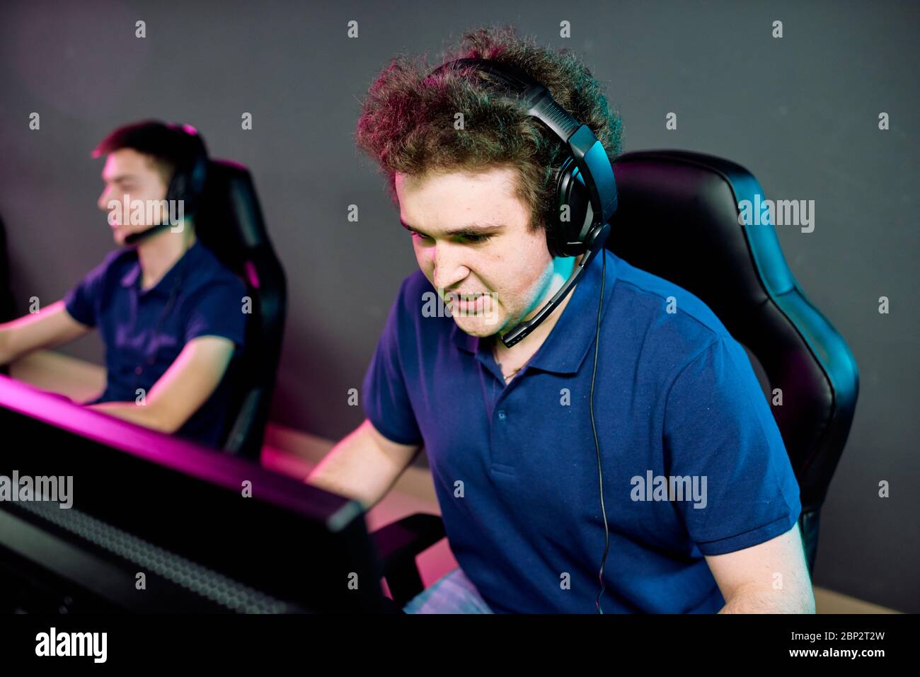 Young operator of e-sport call center in headset looking at computer screen  while commenting network game with tense expression Stock Photo - Alamy