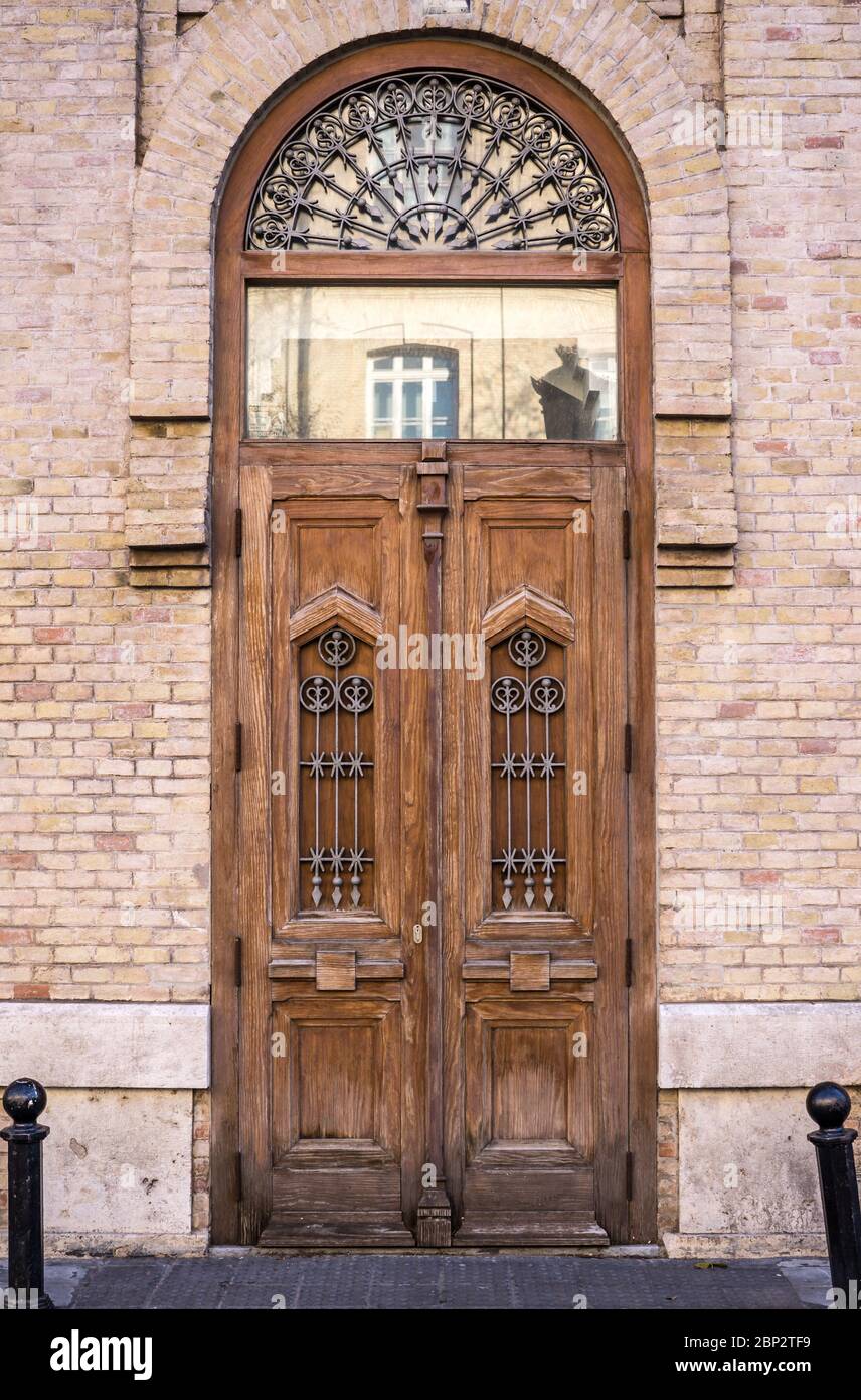 tall wooden door of an old building historic house with exposed brick facade front view. Vertical orientation Stock Photo