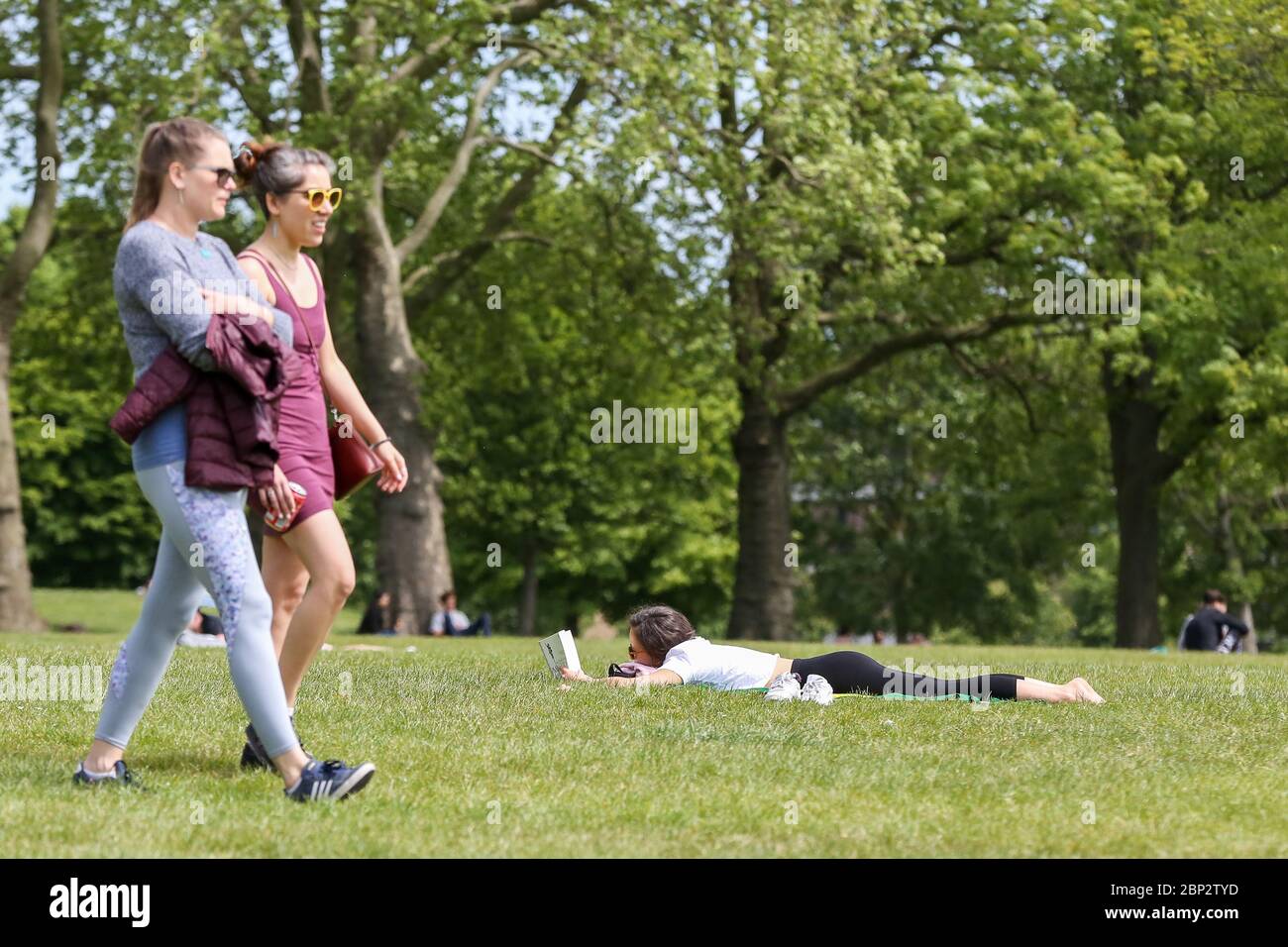 London, UK 17 May 2020 - A woman reads a book in Finsbury Park, north London on the first weekend since the government relaxed the rules on the COVID-19 lockdown, allowing people to spend more time outdoors whilst following social distancing guidelines. According to the Met Office, warmer weather is forecast in the coming week and over the bank holiday weekend.   Credit: Dinendra Haria/Alamy Live News Stock Photo