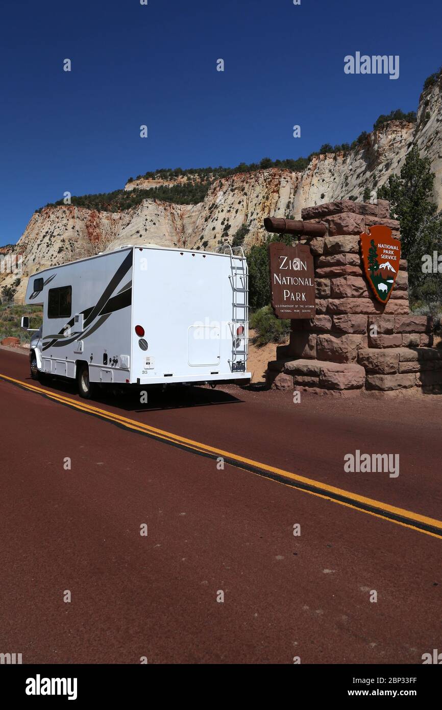 RV camper entering Zion National Park at the entrance sign in Utah Stock Photo