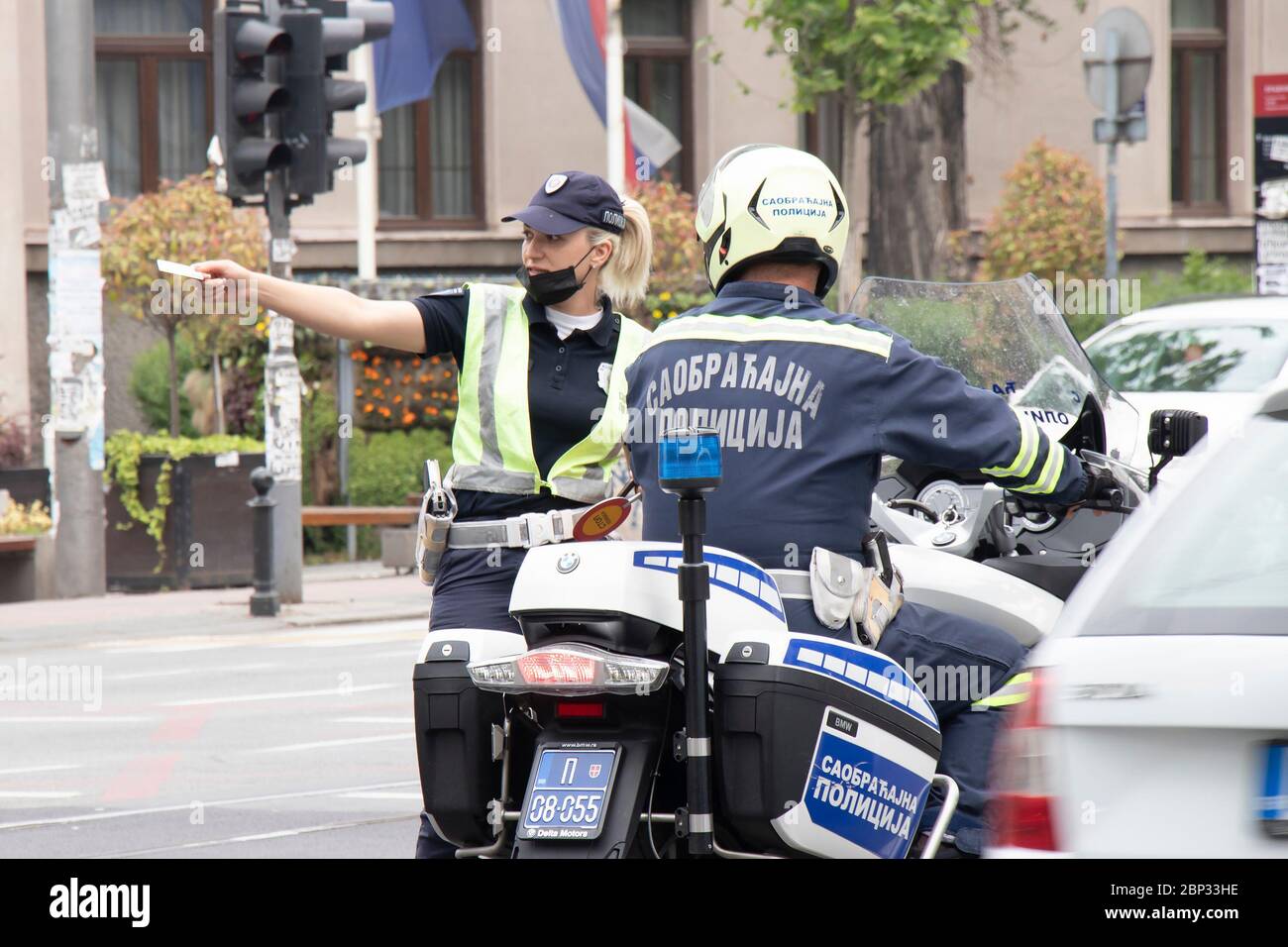 Belgrade, Serbia - May 15, 2020: Traffic policewoman and motor policeman on duty, standing in the intersection and talking Stock Photo