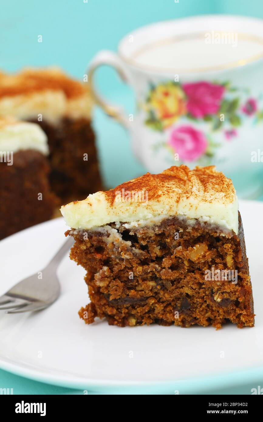 Slice of delicious carrot cake walnuts and marzipan icing on white plate Stock Photo