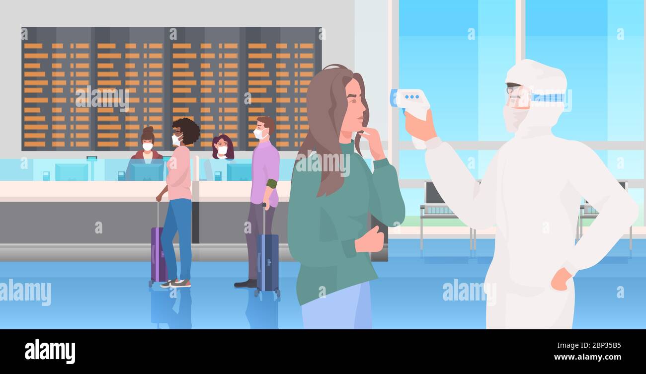 specialist in hazmat suit checking passengers temperature at airport