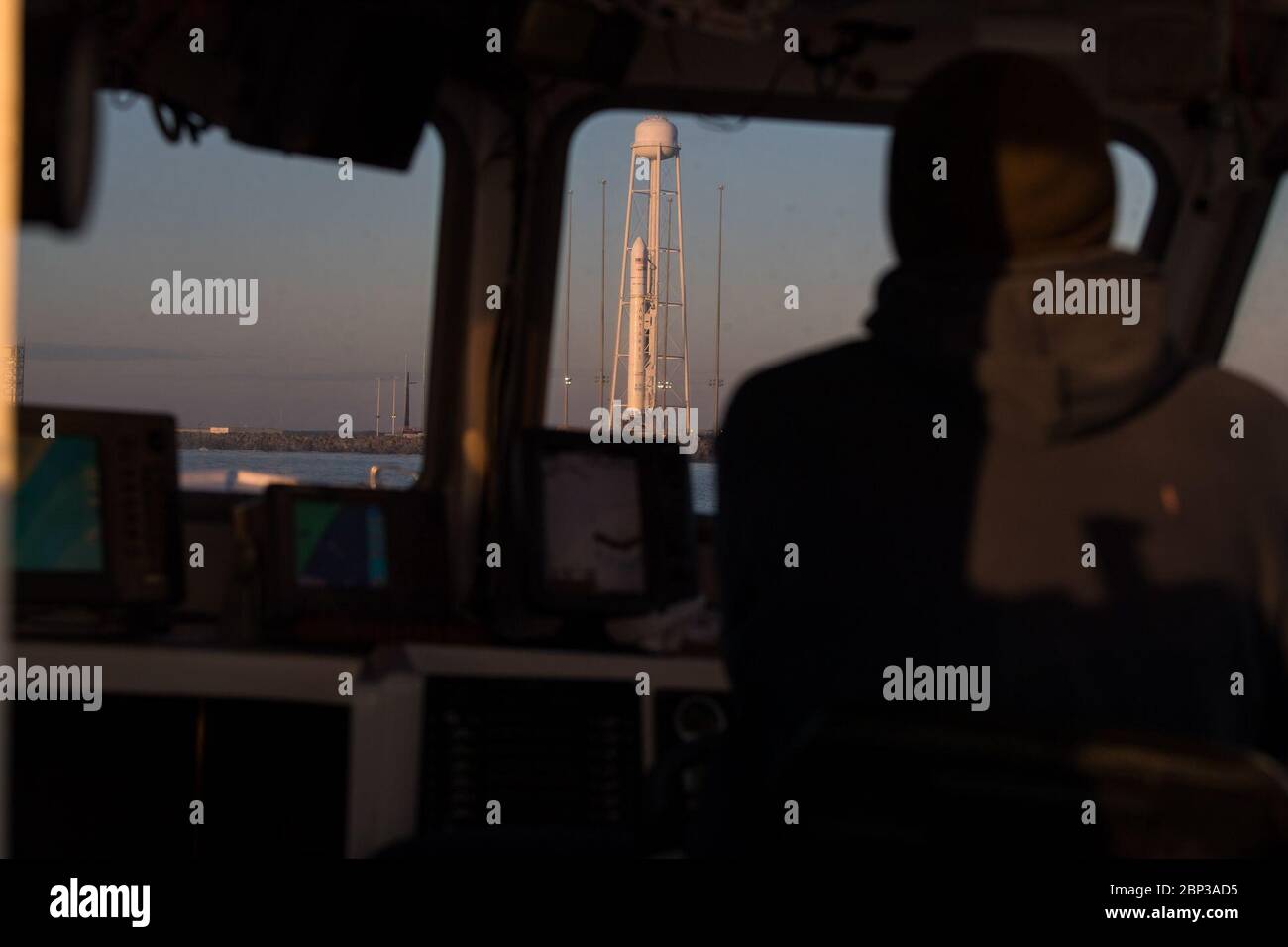 Northrop Grumman Antares CRS-13 Prelaunch A Northrop Grumman Antares rocket carrying a Cygnus resupply spacecraft is seen through a boat window at sunrise on Pad-0A, Sunday, Feb. 9, 2020, at NASA's Wallops Flight Facility in Virginia. Northrop Grumman’s 13th contracted cargo resupply mission with NASA to the International Space Station will deliver more than 7,500 pounds of science and research, crew supplies and vehicle hardware to the orbital laboratory and its crew. The CRS-13 Cygnus spacecraft is named after the first African American astronaut, Major Robert Henry Lawrence Jr.. Stock Photo