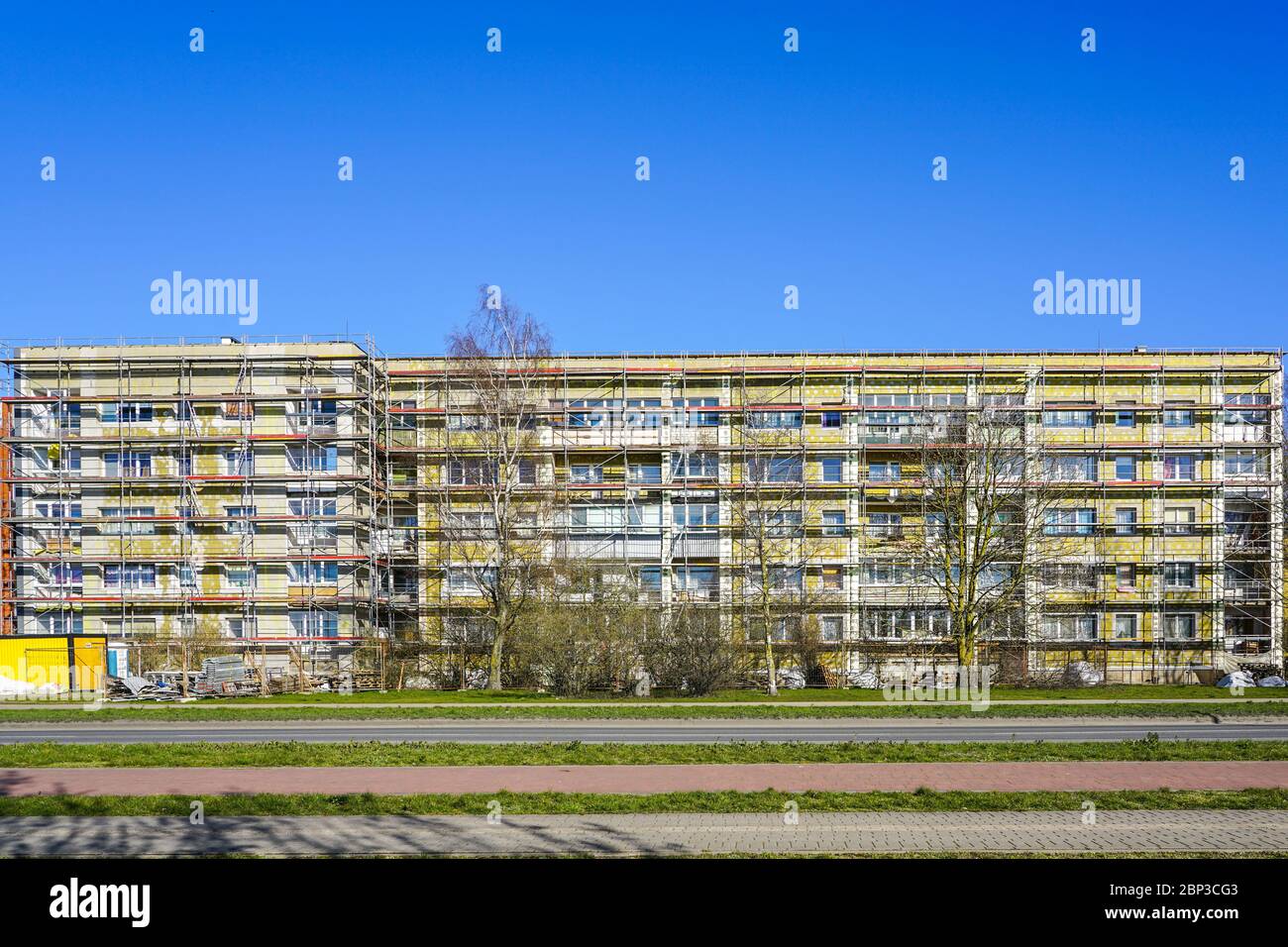 View of apartment house facade renovation and thermal insulation, scaffolding ...