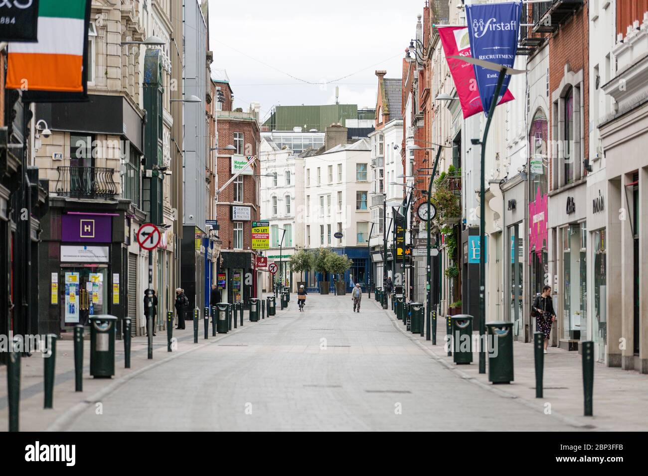 Pedestrians on deserted Grafton Street in Dublin City Centre as the footfall plummets due to coronavirus pandemic. Covid-19 in Ireland. Stock Photo