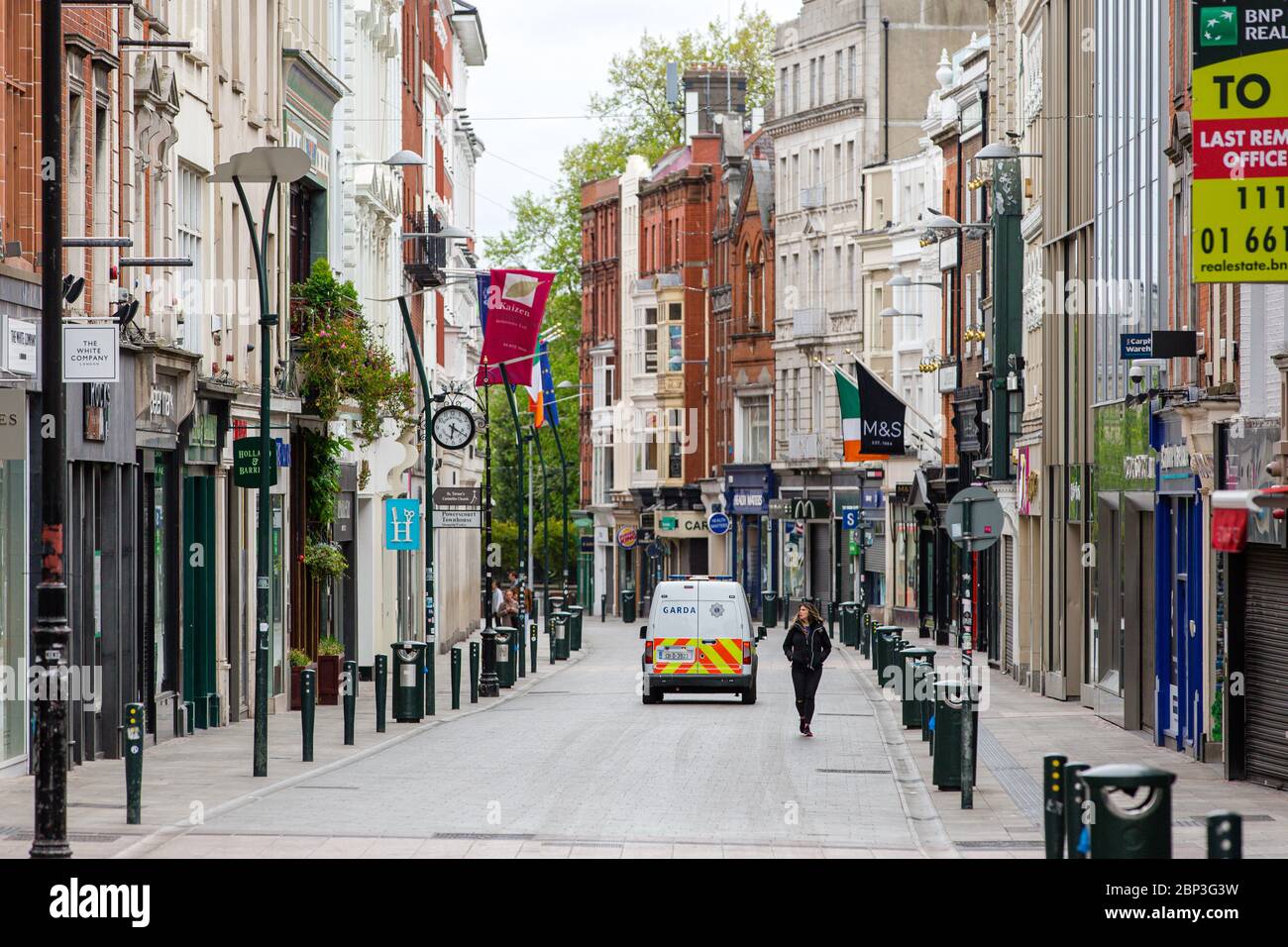 Pedestrians on deserted Grafton Street in Dublin City Centre as the footfall plummets due to coronavirus pandemic. Covid-19 in Ireland. Stock Photo
