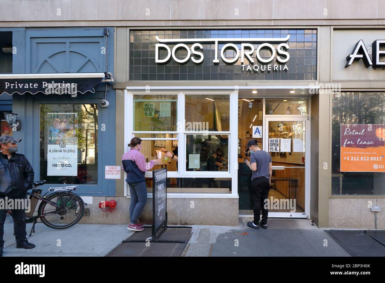 A person picks up an order at a Dos Toros restaurant in New York open-for-business for pickup and delivery only during the coronavirus crisis Stock Photo