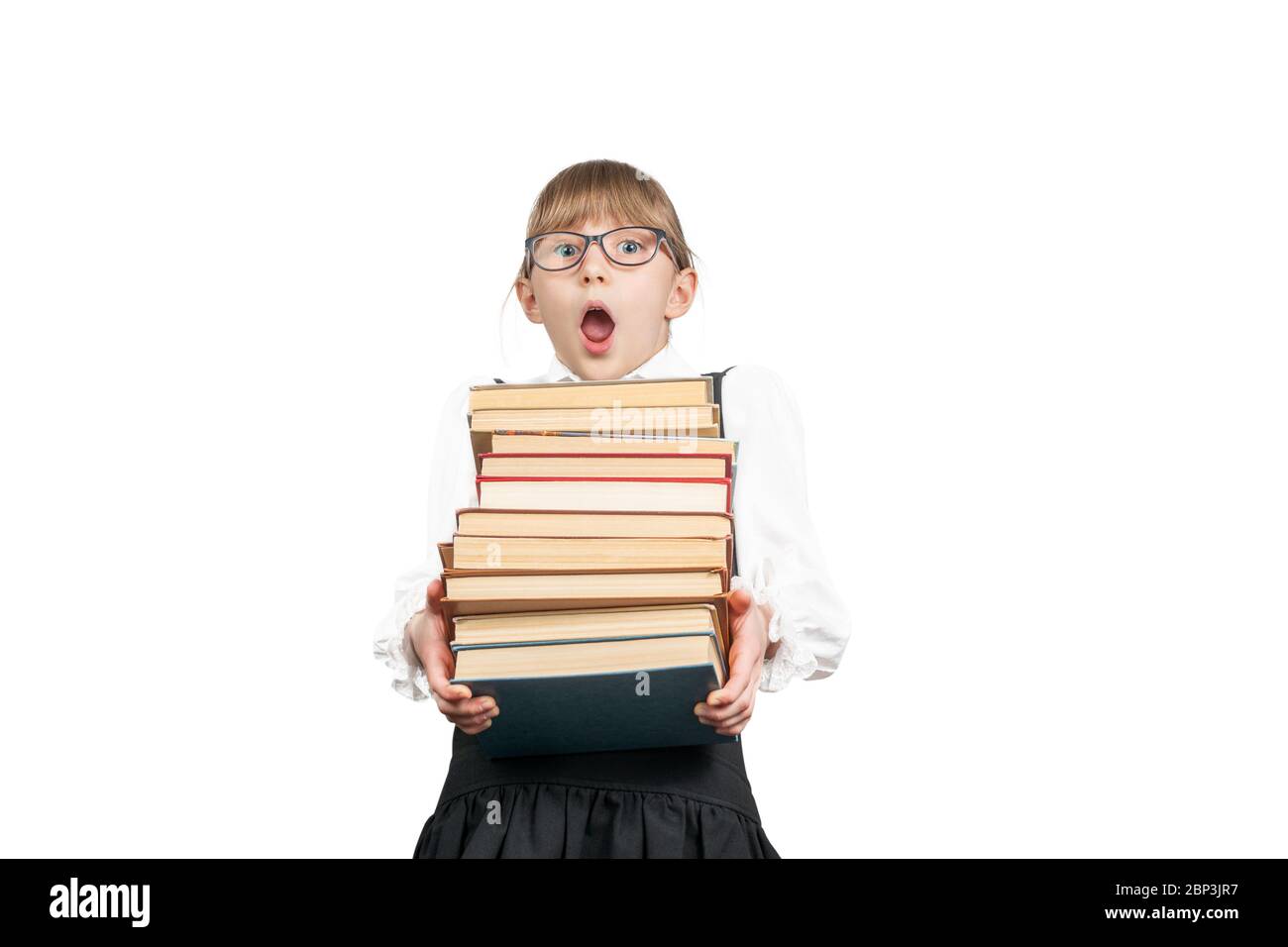 Surprised schoolgirl with glasses carries a stack of books isolated on ...