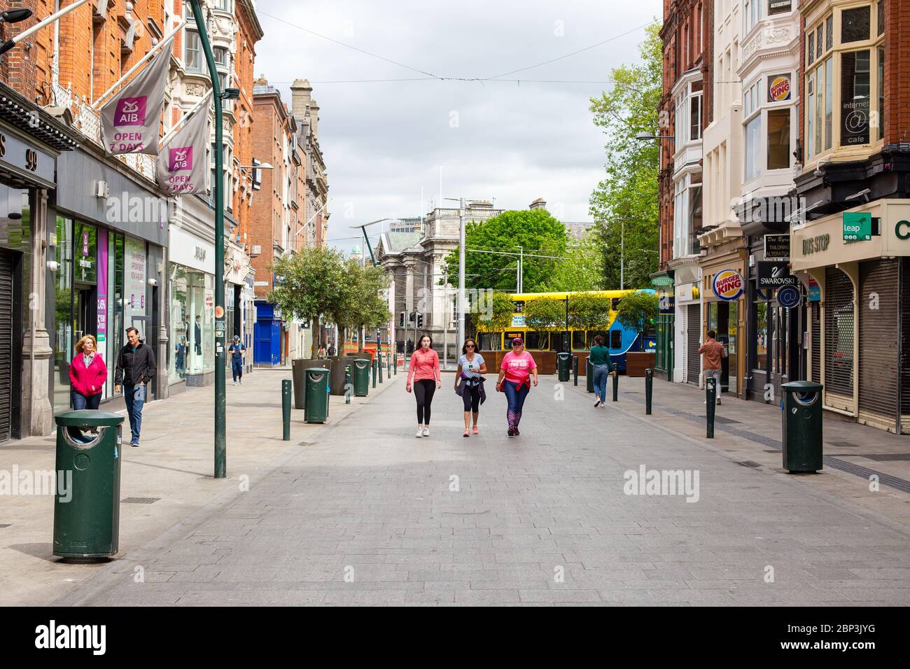 Pedestrians walking through a quiet Grafton Street in Dublin City Centre as the footfall plummets due to coronavirus pandemic. Civid-19 in Ireland. Stock Photo