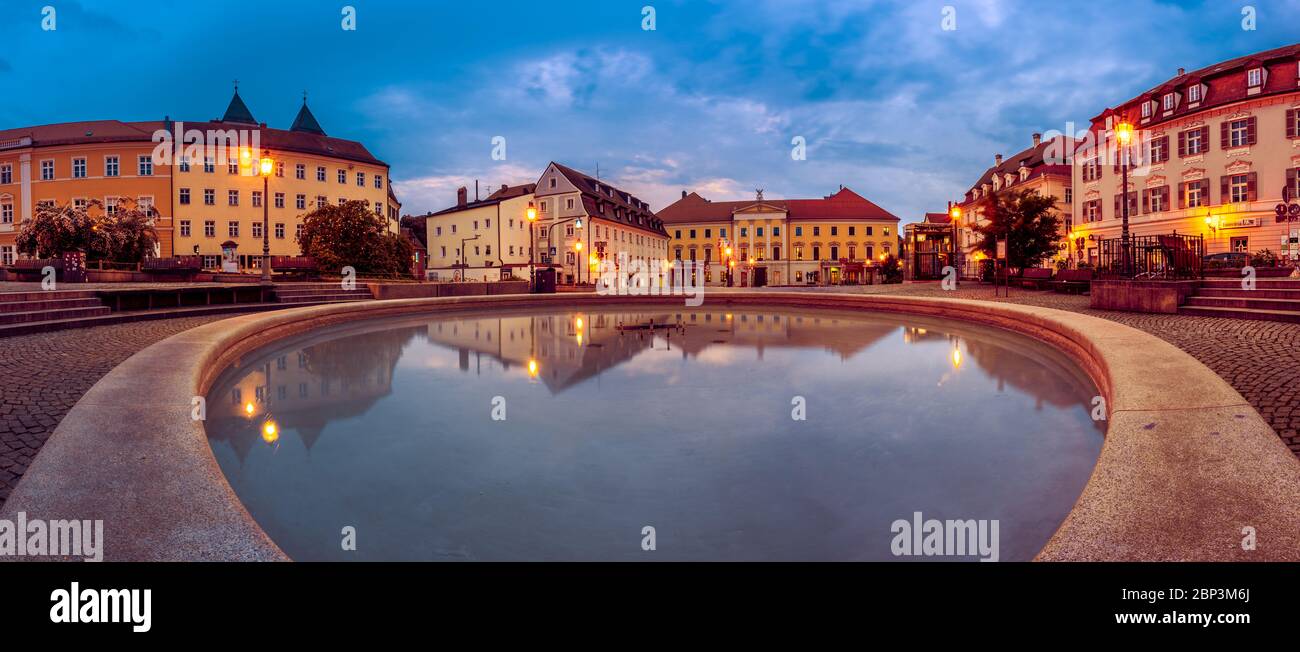 Sophisticated houses and their reflection in well on Bismarckplatz in Regensburg, Germany in early morning during blue hour Stock Photo