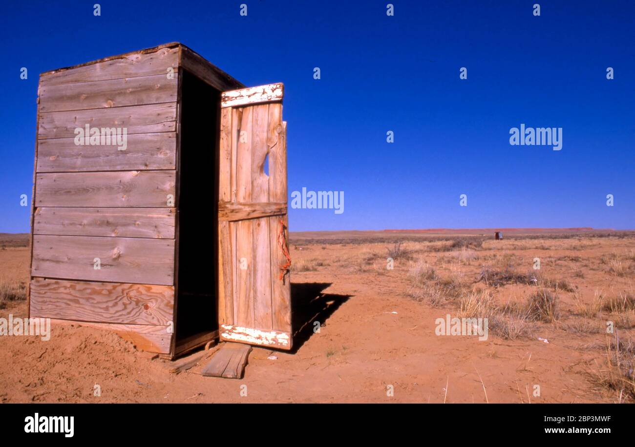 Small wooden toilet in rural aerial against clear blue sky Stock Photo