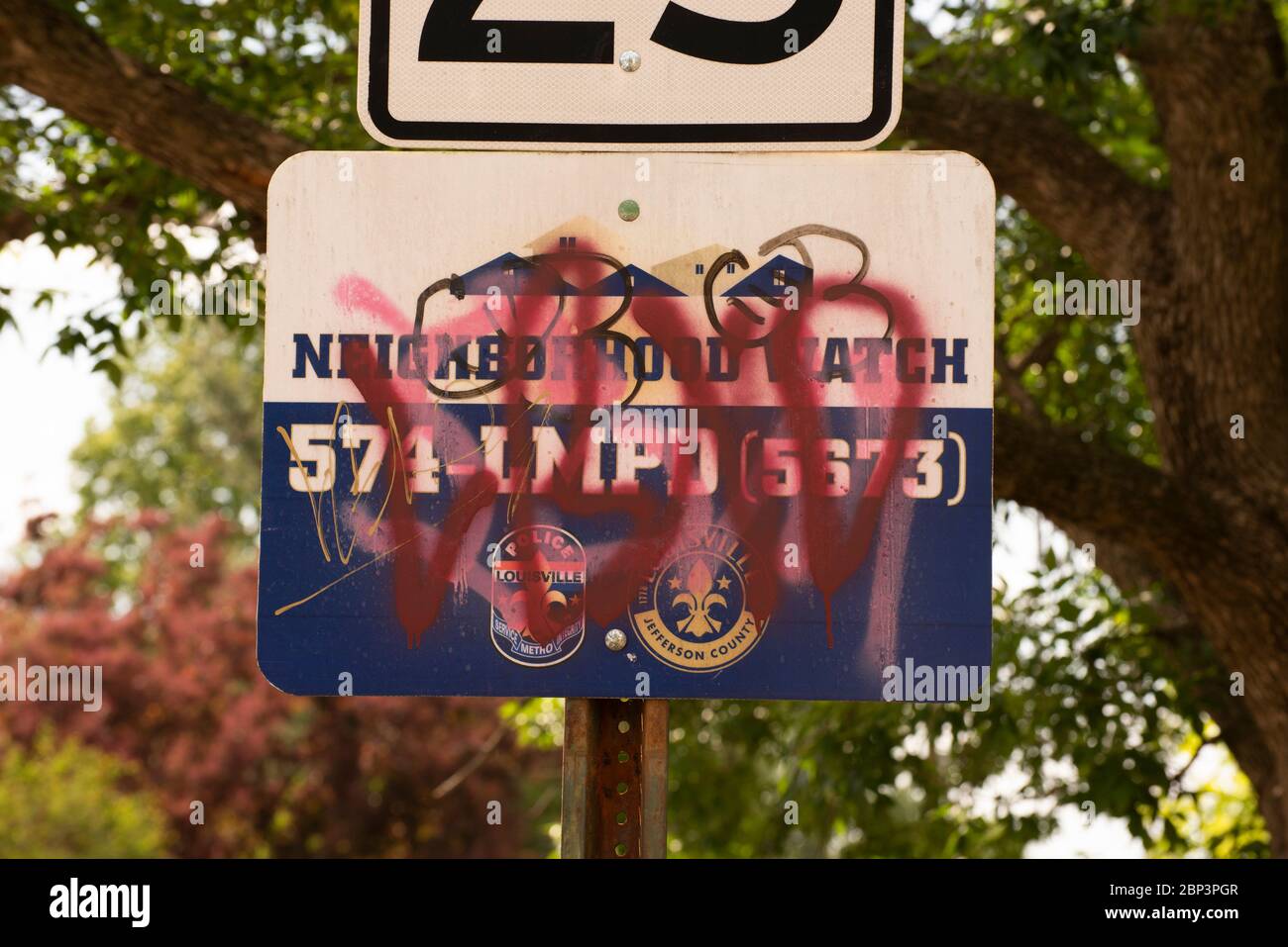 Graffiti covers a Neighborhood Watch sign in Louisville, Kentucky. Stock Photo