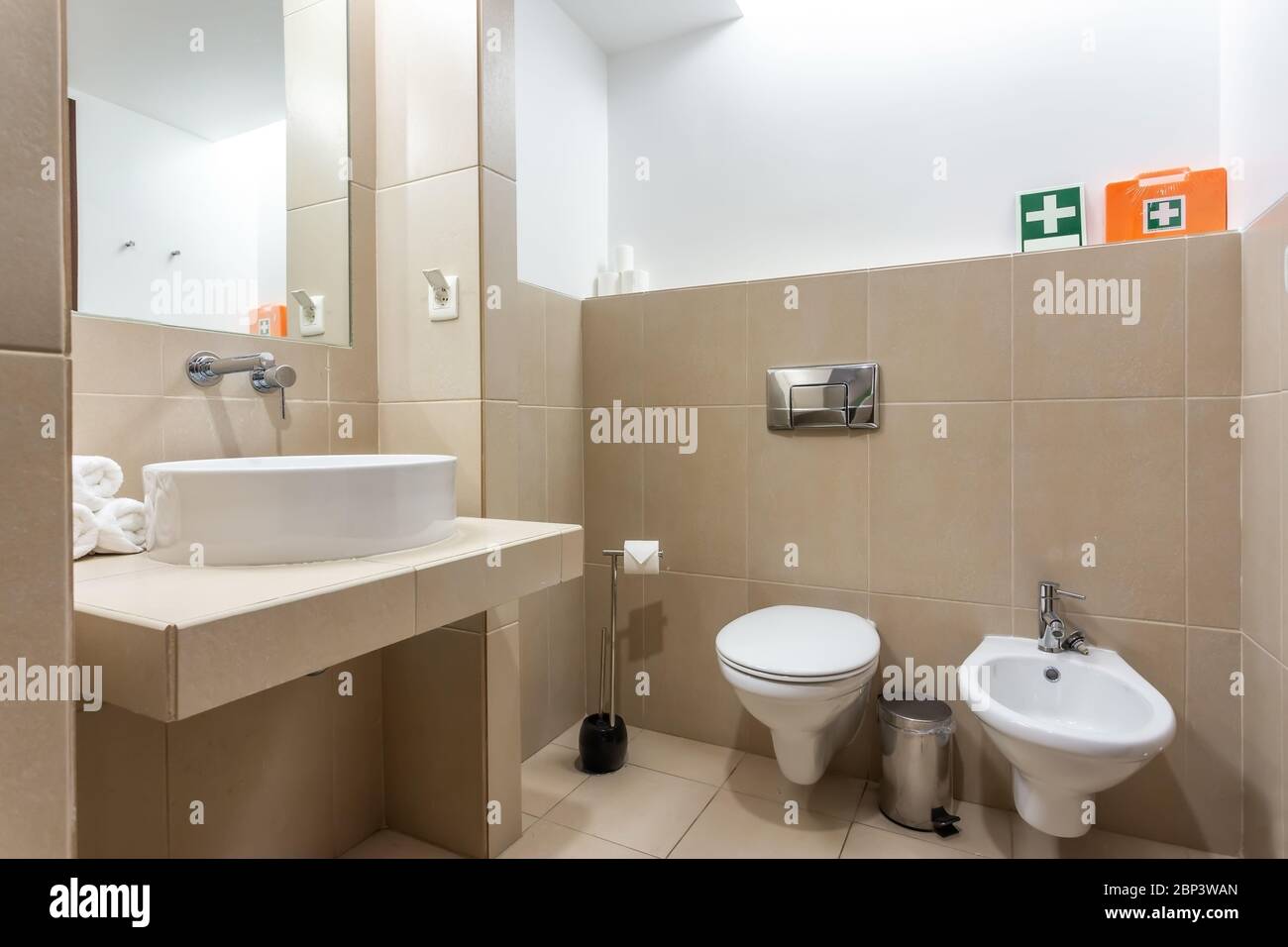 Modern bathroom with bathtub, mirror and washbasin. European hotel