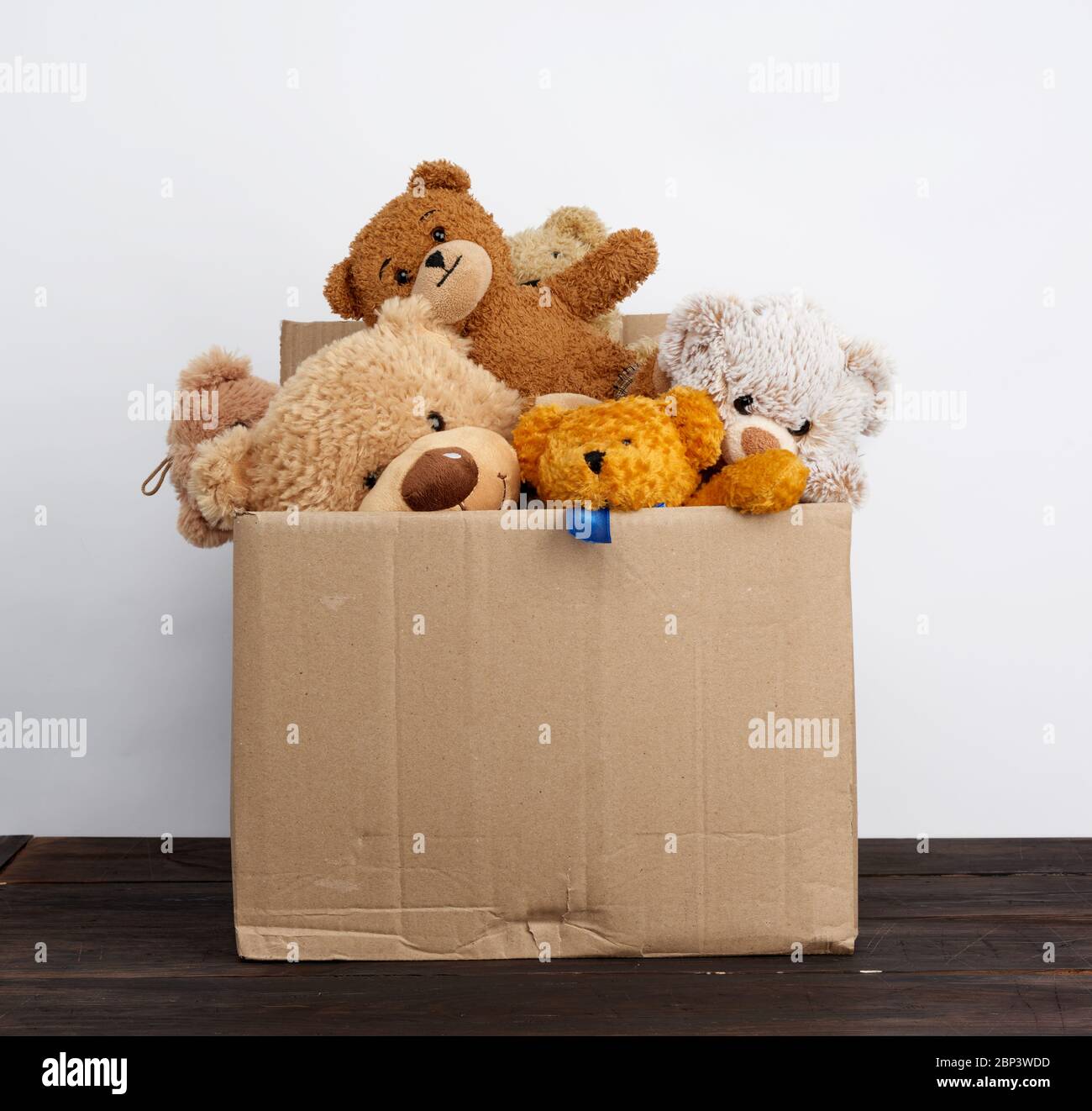 brown cardboard box filled with soft toys, concept of charity and