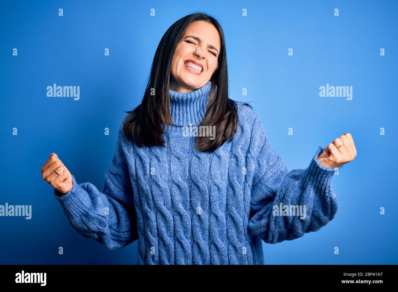 Young brunette woman with blue eyes wearing casual turtleneck sweater ...