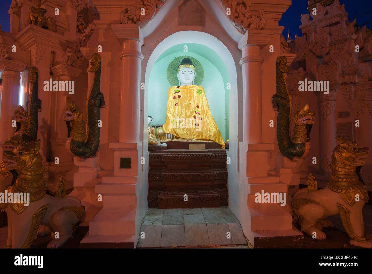 Myanmar travel  Statue or image of Buddha in golden robe in alcove at Shwedagon Pagoda in Yangon, Myanmar. Stock Photo