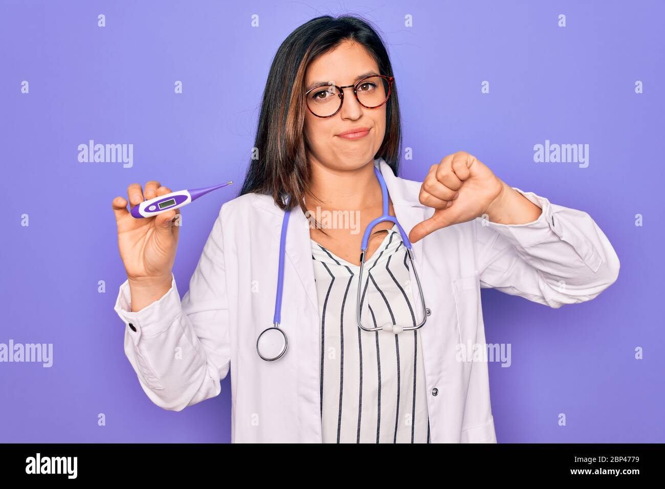 Professional doctor woman showing medical thermometer over purple ...