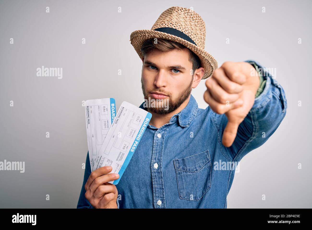Young blond tourist man with blue eyes on vacation wearing hat holding ...