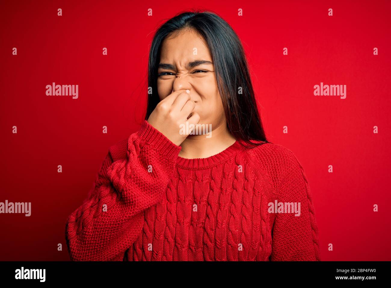 Young beautiful asian woman wearing casual sweater standing over ...