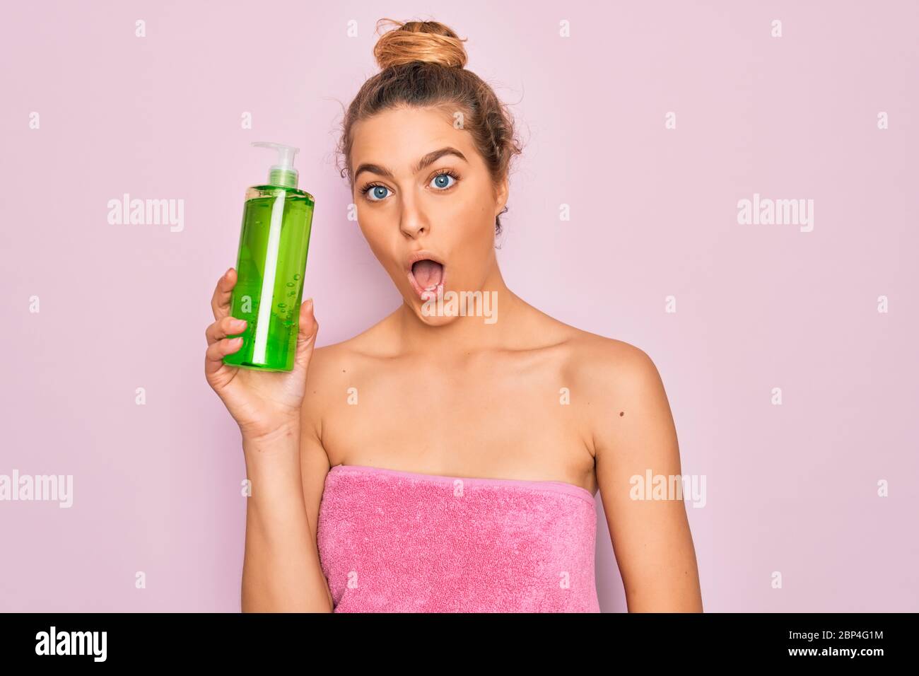 Beautiful blonde woman with blue eyes wearing towel shower after bath