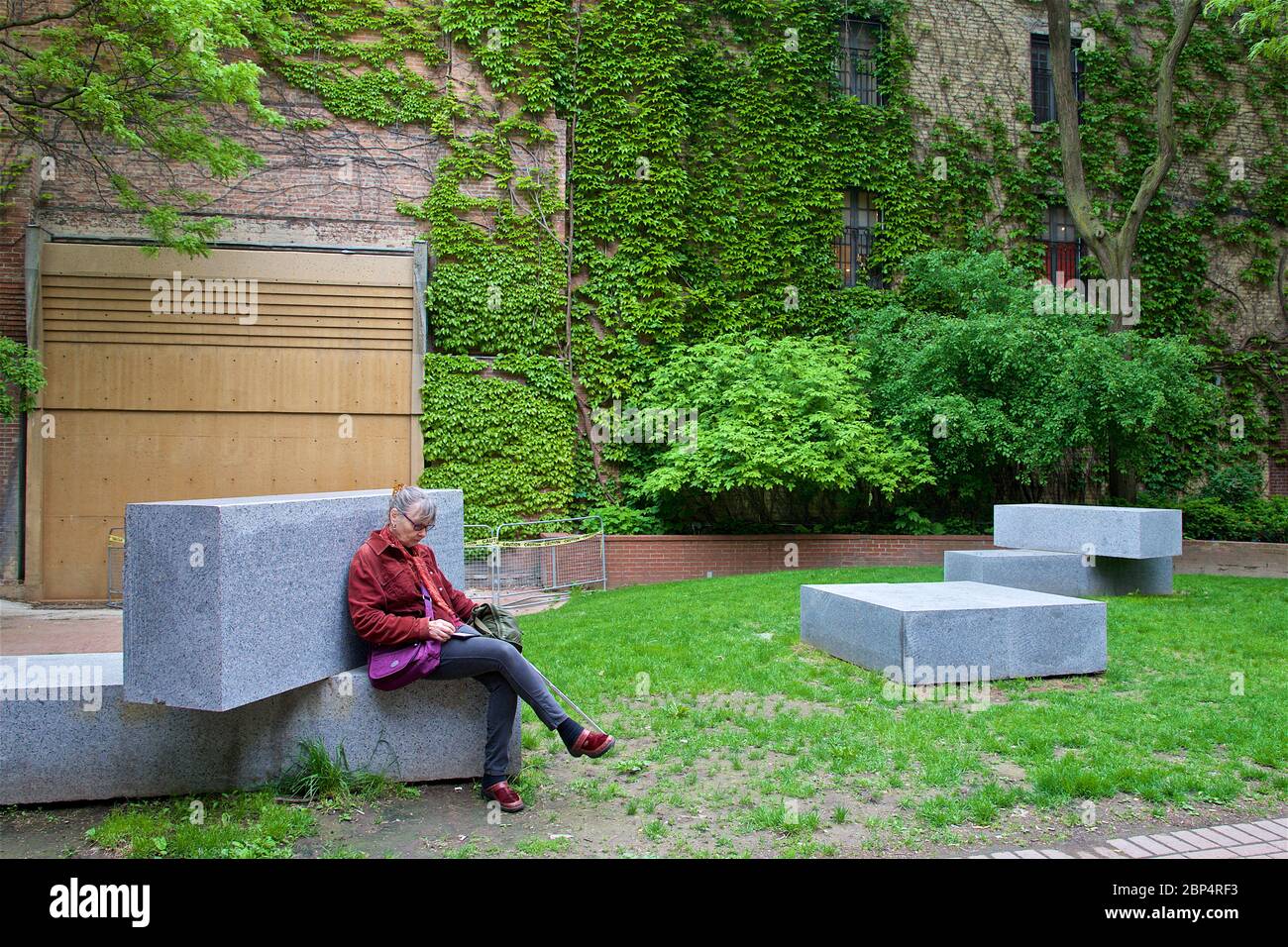 Toronto, Ontario / Canada - 06/05/2017: Woman sitting at Market Lane Park in downtown Toronto to read the new messages from her cell phone Stock Photo