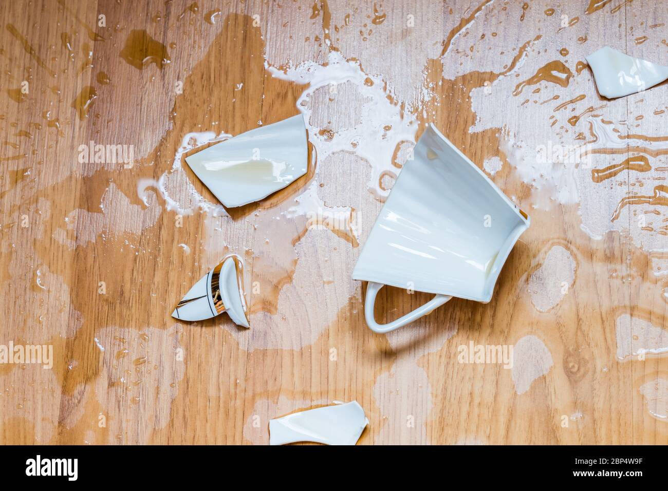 Broken cup with spilled tea on a floor Stock Photo Alamy
