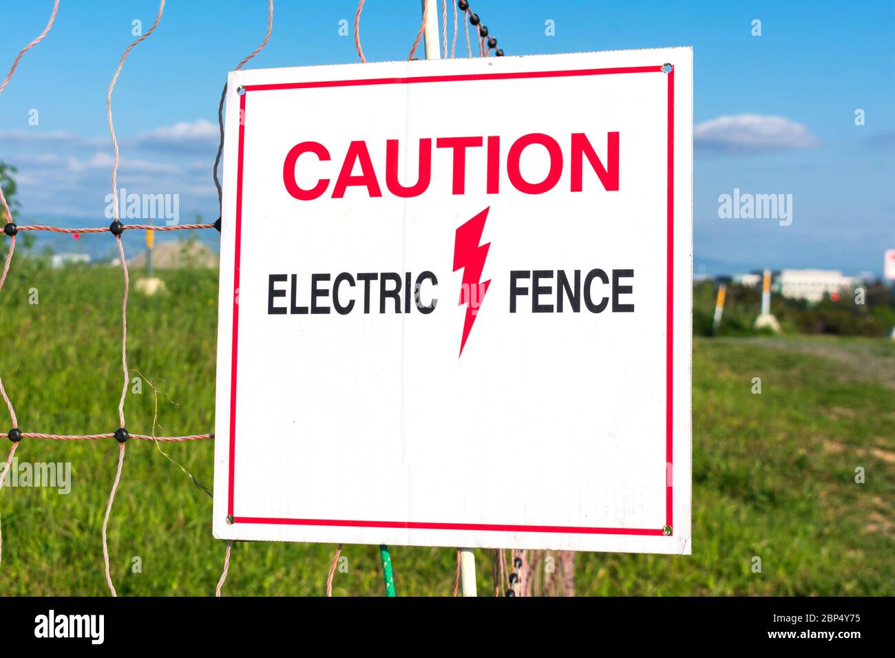 Caution Electric Fence warning sign makes people aware of the electrified fence. Stock Photo